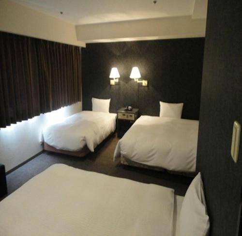 a hotel room with two beds in a room at Green Rich Hotel Nishitetsu Ohashi Ekimae in Fukuoka
