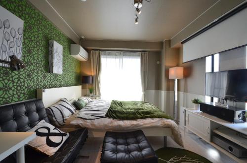 a small bedroom with a bed and a couch at Apartment Zen Hotel in Mizuho