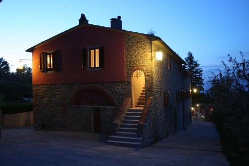 a stone building with stairs leading up to a door at Agriturismo La Forra in Cavriglia