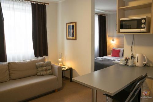 a living room with a couch and a table and a bed at Old Tree Villa & Restaurant in Oświęcim