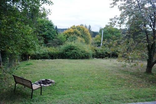 a park bench sitting in the grass with a dog sleeping at Beautiful and Spacious Contemporary house in Oignies-en-Thierache