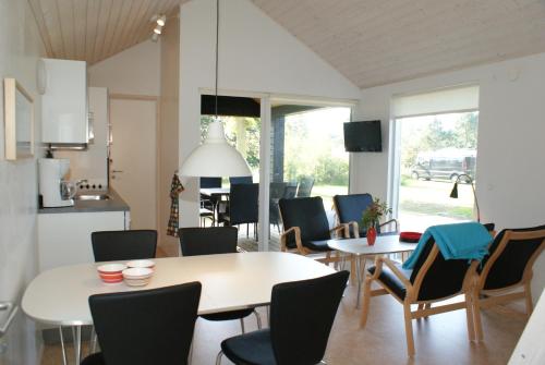 a kitchen and dining room with tables and chairs at Læsø Camping & Hytteby in Vesterø Havn