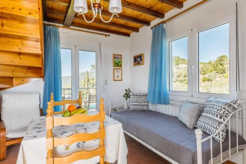 a bedroom with a bed and two windows at Villa Thea in Panormos Skopelos