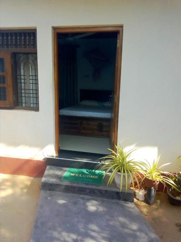Zimmer mit einem Bett in einem Gebäude mit Pflanzen in der Unterkunft Nethmi Rooms in Negombo