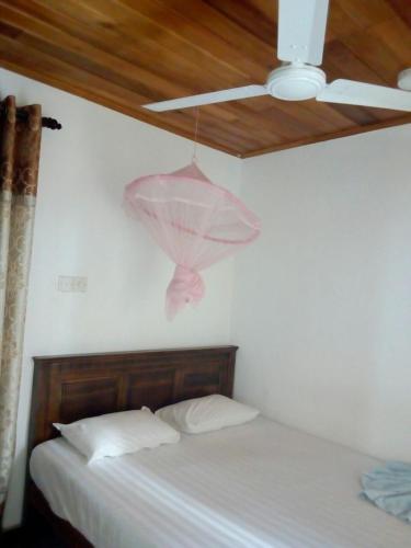 a bedroom with two beds and a ceiling fan at Nethmi Rooms in Negombo