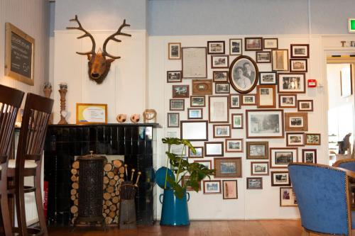 a wall of pictures on a wall with a fireplace at Hotel Jans in Rijs