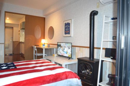a bedroom with a bed and a stove in it at Apartment Zen Hotel in Mizuho