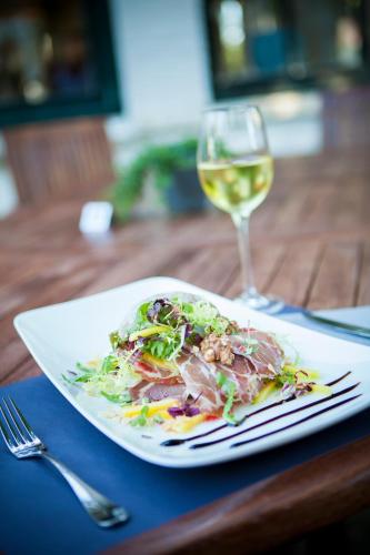 a plate with a salad and a glass of wine at Hotel Jans in Rijs