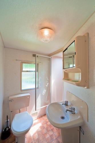 a bathroom with a white toilet and a sink at The Garda Village in Sirmione