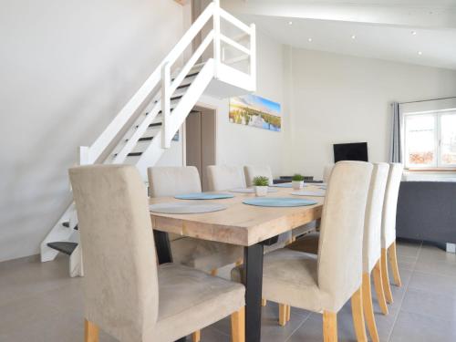 a dining room with a wooden table and chairs at Quaint Cottage in Mont near High Fens Nature Park in Malmedy