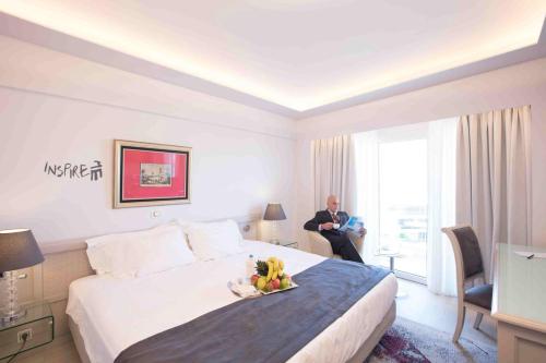 a hotel room with a bed with a bowl of fruit on it at St George Lycabettus Lifestyle Hotel in Athens