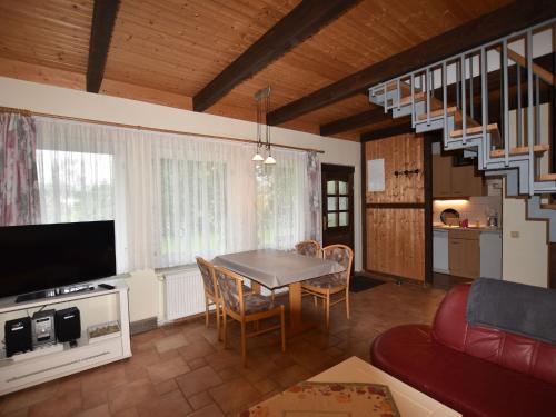 Una sala de estar con una mesa y una escalera. en Ferienhaus in Neubukow mit Terrasse, en Neubukow