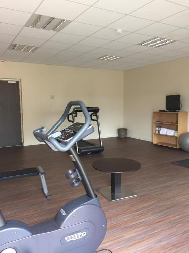 a room with a gym with a treadmill and a table at Mercure Aix-En-Provence Sainte-Victoire in Châteauneuf-le-Rouge