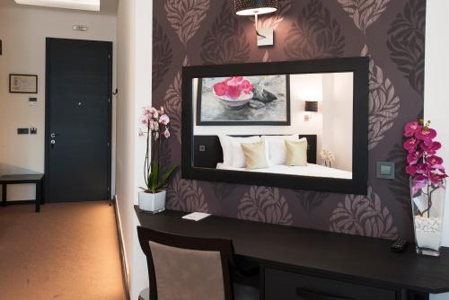 a mirror on a wall in a room at Garni Hotel Zen free parking in Niš