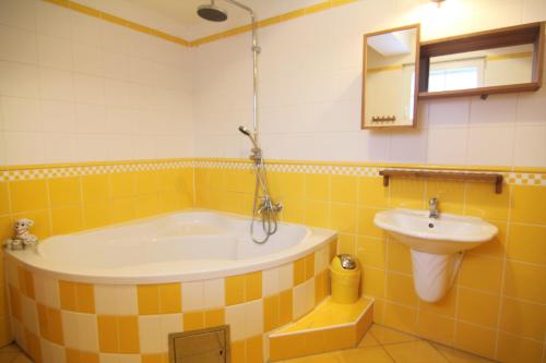 a bathroom with a tub and a sink at Hotel Restaurant Svejk in Bublava