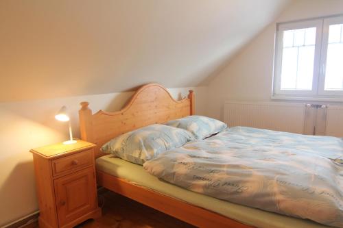 a bedroom with a bed with a wooden headboard and a lamp at Hotel Restaurant Svejk in Bublava