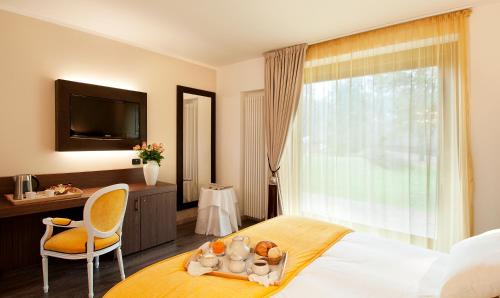 a hotel room with a bed and a tv and a window at Bed&Garden in Cesate