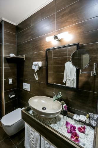 a bathroom with a sink and a toilet and a mirror at Garni Hotel Zen free parking in Niš