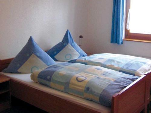 a bed with blue comforter and pillows on it at Holiday Home in Germany with Garden Terrace in Bredenborn