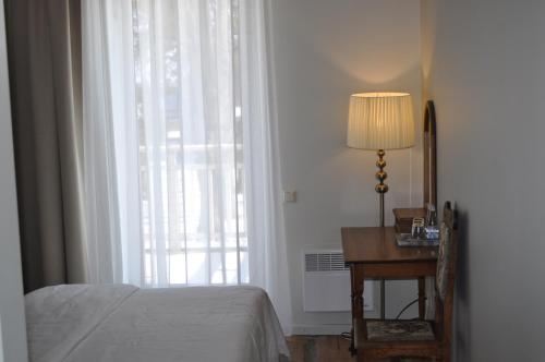 a bedroom with a bed and a desk and a window at Meke in Mustkalni