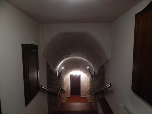 a long hallway with a tunnel with a light at the end at Hotel Zámeček Pod Hradem Starý Jičín 111 in Starý Jičín