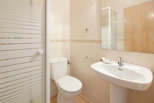 a white bathroom with a toilet and a sink at Musika Plaza in Zarautz
