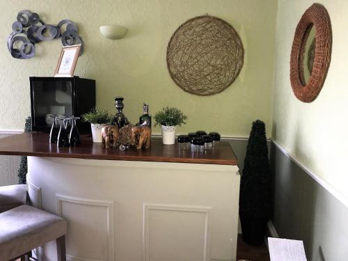 a bar with bottles and glasses on a counter at Beechwood Ensuite Guest House in Ayr