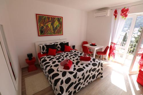 a bedroom with a black and white bed with red pillows at Meridiens in Dubrovnik