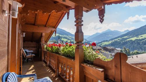 a balcony of a wooden house with flowers on it at Appartement Alpina in Alpbach