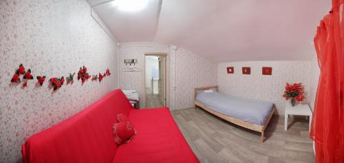 ヴィボルグにあるДвухэтажный коттедж Scandi Gold с сауной и зона барбекю На природе Выборгの赤いソファとベッドが備わる小さな客室です。