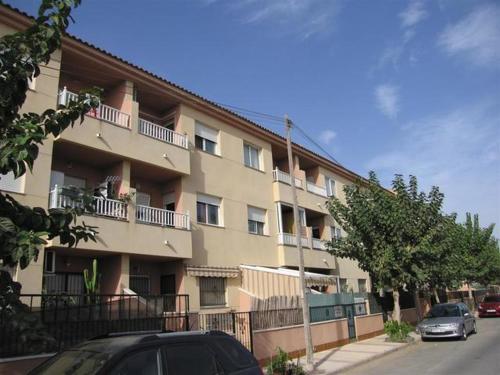a large apartment building with cars parked in front of it at APARTAMENTO D&L CON ENCANTO- EN LOS ALCÀZARES-Totalmente equipado in Los Alcázares