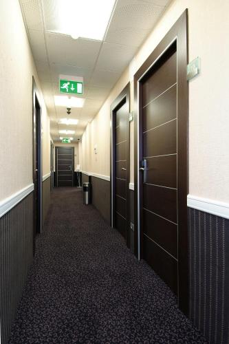 a hallway of an office building with brown doors at EH Rome Airport Euro House Hotels in Fiumicino