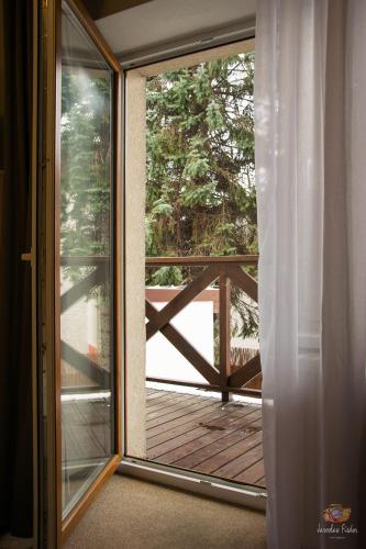 a sliding glass door leading to a porch with a deck at Old Tree Villa & Restaurant in Oświęcim