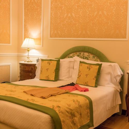 a bedroom with a bed with two pillows at Hotel Bernini Palace in Florence