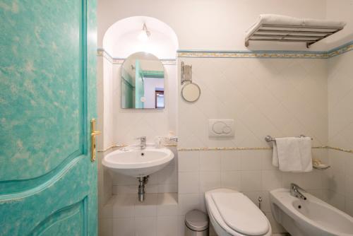 a bathroom with a sink and a toilet and a mirror at Ricciolo d'oro 1 in Positano