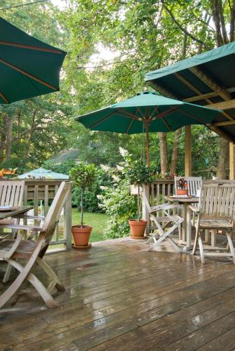 a deck with tables and chairs and umbrellas at Marshall Slocum Inn in Newport