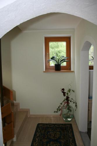 a hallway with a window and a plant in a vase at Haus Mitti in Heinfels