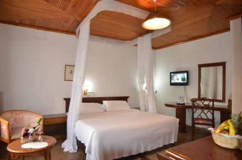 GilgilJacaranda Lake Elementaita Lodge的带天篷床的卧室
