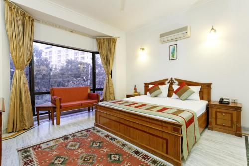 1 dormitorio con 1 cama, 1 silla y 1 ventana en Silver Oak, en Gurgaon