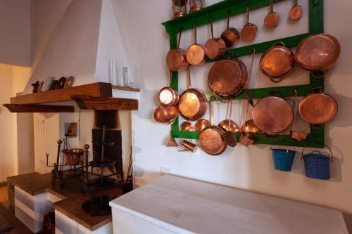 eine Küche mit Töpfen und Pfannen, die an der Wand hängen in der Unterkunft Podere Il Lampo in Montalcino
