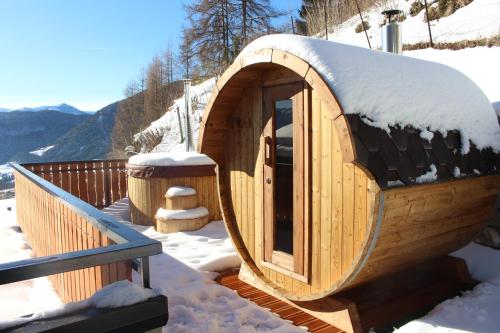 a wooden hobbit house with snow on the roof at B&B Navertino in Borno