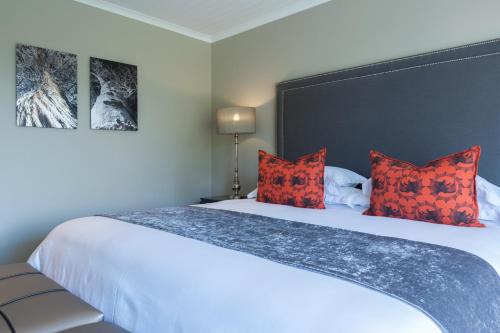 a bedroom with a large white bed with red pillows at The Jordan Suites in Stellenbosch