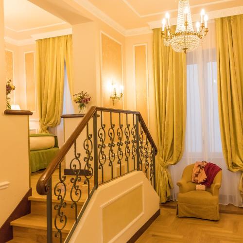 a living room with a staircase and a chandelier at Hotel Bernini Palace in Florence