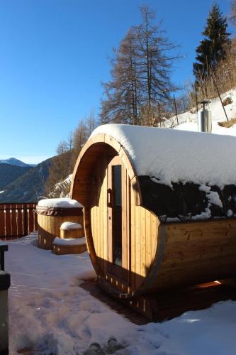 a wooden cabin with snow on top of it at B&B Navertino in Borno