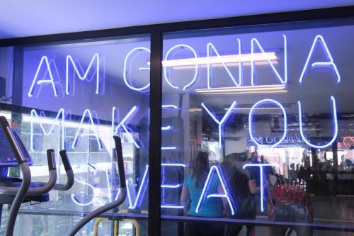 a neon sign in the window of a store at Hamra Urban Gardens in Beirut