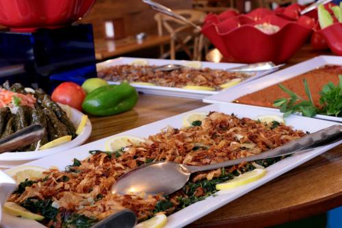 a table topped with plates of food with a spoon at Hamra Urban Gardens in Beirut