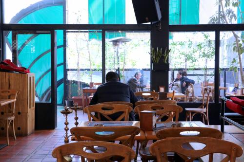 a man sitting at a table in a restaurant at Hamra Urban Gardens in Beirut