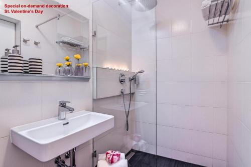 ein weißes Badezimmer mit einem Waschbecken und einem Spiegel in der Unterkunft Terrace Apartment Prague in Prag