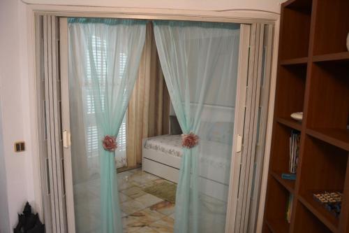 クアルテイラにあるQuinta do Romãoの青いカーテン付きのベッドルーム1室、ベッド1台が備わるベッドルーム1室が備わります。