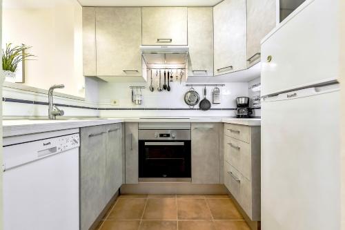 a kitchen with white cabinets and a white refrigerator at Tenerife cerca del aeropuerto in San Isidro